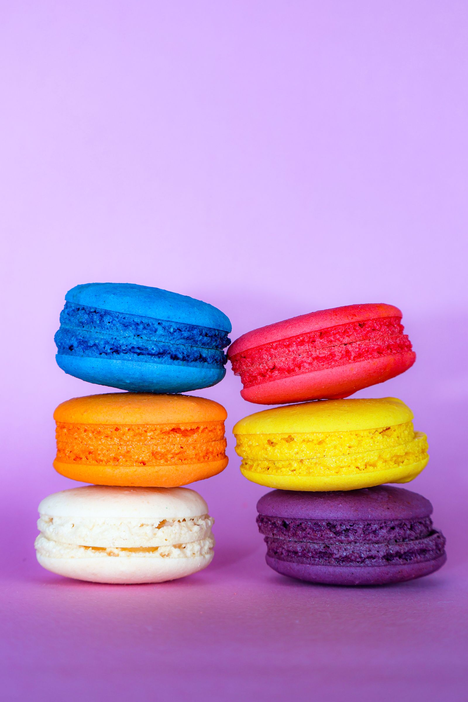 Kleurrijke macarons op een lavendelkleurige achtergrond